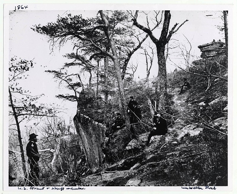 Gen. Ulysses S. Grant on Lookout Mountain near Missionary Ridge in 1863. Four men in uniform pose near the edge of the cliff, while one sits further back on the path. The other four are, left to right, as Gen. John A. Rawlins, Gen. J.D. Webster, Col. Clark B. Lagow and Col. Willam S. Hillyer.