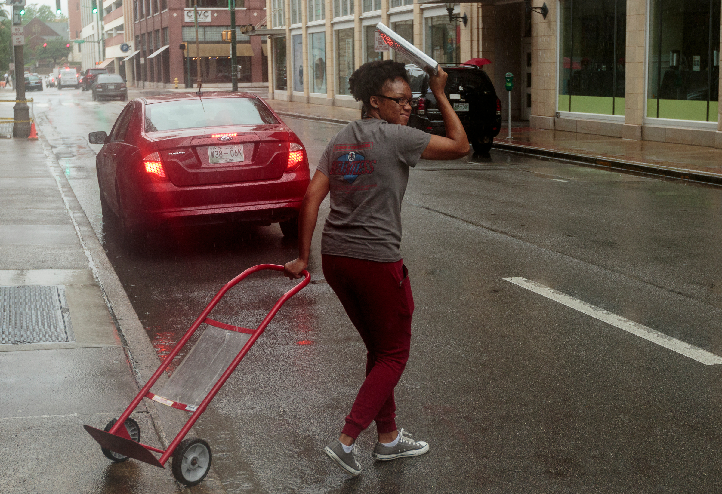 Michelle Bradley covers her head as she moves a hand cart to her vehicle after tropical storm Cindy brought rainfall to the region on Thursday, June 22, 2017, in Chattanooga, Tenn. Rain is expected to continue through Saturday.