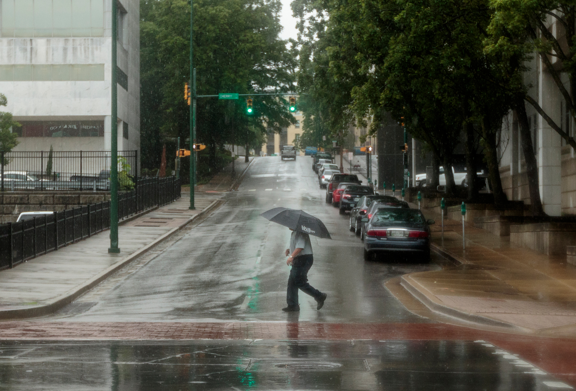 A pedestrian crosses Sixth Street at Market Street after tropical storm Cindy brought rainfall to the region on Thursday, June 22, 2017, in Chattanooga, Tenn.