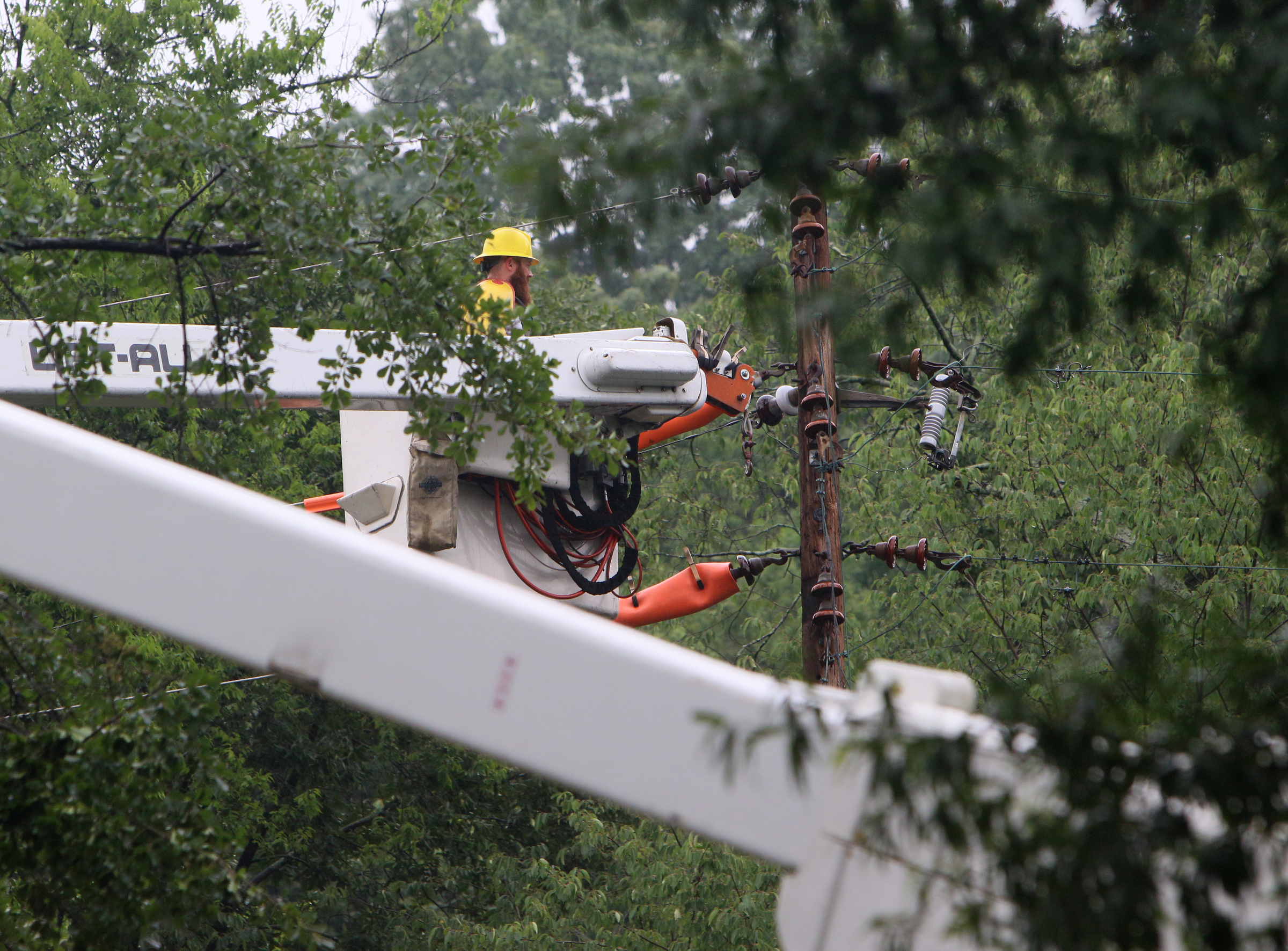 Joe Vineyard, a lineman working for EPB, installs temporary dead ends onto a power line to be repaired where a tree fell on a car at the corner of Stuart Street and Campbell Street on Thursday, June 22, 2017, in Chattanooga, Tenn. Roads were blocked and utility workers were on scene for a few hours repairing power lines and removing the tree from the car.