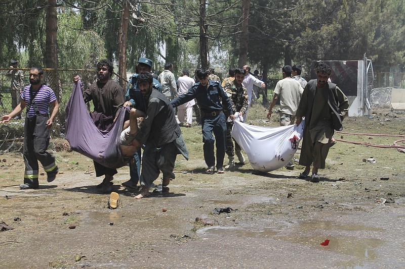 
              Afghans carry the bodies of men at after a suicide car bombing in Helmand province southern of Kabul, Afghanistan, Thursday, June 22, 2017. The bomber struck outside a bank, targeting Afghan troops and government employees waiting to collect their salaries ahead of a major Muslim holiday and killing at least two dozen people, officials said. (AP Photo/Abdul Khaliq)
            