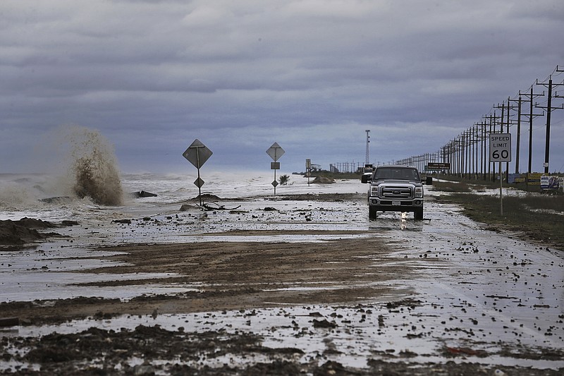
              Vehicles navigate past waves and debris washing over State Highway 87 as Tropical Storm Cindy approaches Wednesday, June 21, 2017, in High Island, Texas. (Michael Ciaglo/Houston Chronicle via AP)
            