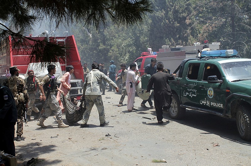 
              Afghans carry an injured man after a suicide car bombing in Helmand province southern of Kabul, Afghanistan, Thursday, June 22, 2017. The bomber struck outside a bank, targeting Afghan troops and government employees waiting to collect their salaries ahead of a major Muslim holiday and killing at least two dozen people, officials said. (AP Photo/Abdul Khaliq)
            