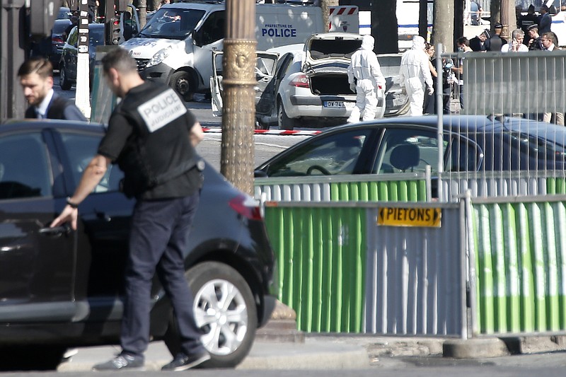 
              Scientific police officers investigate on the suspected car, center rear, after a man rammed into a police convoy on the Champs Elysees avenue in Paris, Monday, June 19, 2017. France's interior minister says the attempted attack on security forces on the Champs-Elysees shows the threat is still very high in the country and justifies the state of emergency. (AP Photo/Thibault Camus)
            