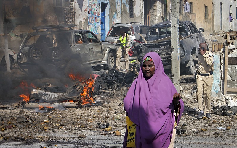 
              A Somali woman walks past the scene of a suicide car bomb attack on a police station in Mogadishu, Somalia Thursday, June 22, 2017. A number of people are dead and several others wounded in the blast in Somalia's capital, police said Thursday, adding that the bomber was trying to drive into the police station's gate but detonated against the wall instead. (AP Photo/Farah Abdi Warsameh)
            