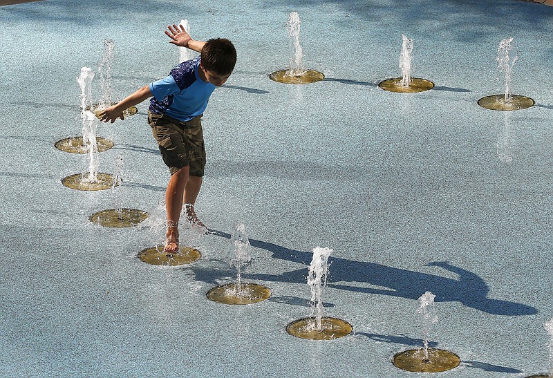
              One person uses the CityScape splash pad to stay cool as temperatures climb to near-record highs Tuesday, June 20, 2017, in Phoenix. The National Weather Service forecasts a high of 120 degrees (49 degrees Celsius), which is has only hit three times in recorded history in Phoenix, the last time 22 years ago. (AP Photo/Ross D. Franklin)
            