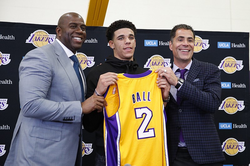 
              Los Angeles Lakers' Lonzo Ball, center, poses for photos with Magic Johnson, left, and general manager Rob Pelinka during a news conference, Friday, June 23, 2017, in El Segundo, Calif. (AP Photo/Jae C. Hong)
            
