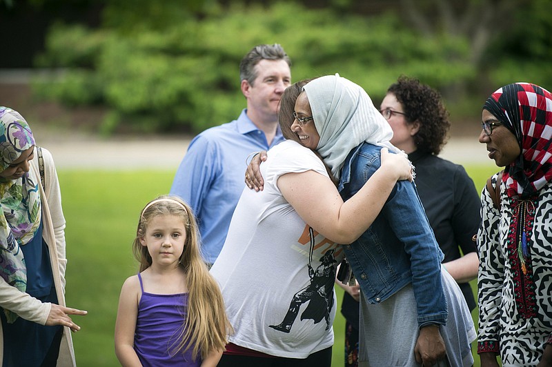 
              Rachael Hannah hugs Einas Shalabi after the Flint Islamic Center's interfaith prayer service on Thursday, June 22, 2017, in Flint, Mich.,  for Lt. Jeff Neville, who was stabbed at Bishop Airport Wednesday morning. "I felt so obliged, morally, that I have to come, support and be a part of this. This is my first time attending an interfaith ceremony and I feel like there is a lot of positive energy here. Each and everyone prayed with their own language and own prayer but they were all asking for the same thing," said Shalabi, of Grand Blanc, Mich. (Shannon Millard /The Flint Journal-MLive.com via AP)
            
