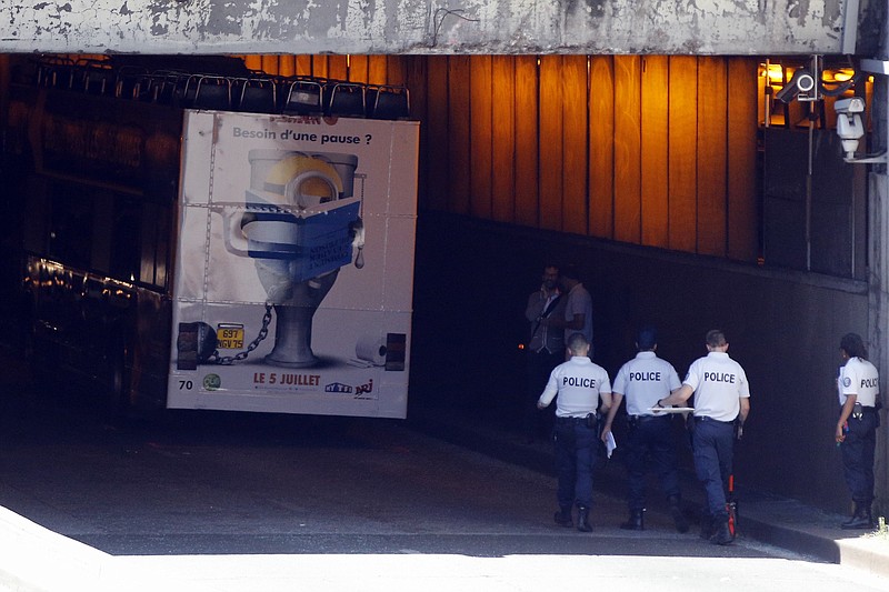
              French police officers walk to a bus that hit the roof of a Paris tunnel, Friday, June 23, 2017 . A tour bus company says one of its double-decker, open-roof buses hit the roof of a Paris tunnel, injuring four people, one of them seriously. (AP Photo/Thibault Camus)
            