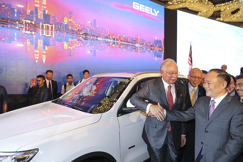 
              Malaysian Prime Minister Najib Razak shakes hand with Zhejiang Geely Holding Group Chairman Li Shufu, right, after a signing ceremony for Proton and Geely in Kuala Lumpur, Malaysia, Friday, June 23, 2017. Geely, the Chinese owner of Sweden’s Volvo Cars, will inject 170.3 million ringgit ($40 million) into Malaysia’s Proton as part of its purchase of a stake in the automaker and is paying 51 million pounds ($65 million) for 51 percent of Proton-owned British sports car maker Lotus, an executive of the Malaysian company said Friday. (AP Photo/Vincent Thian)
            