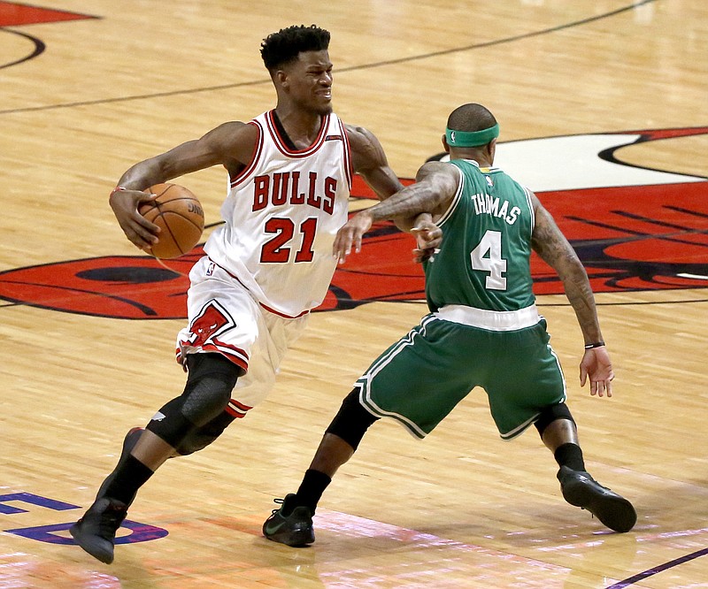 FILE - In this April 23, 2017, file photo, Chicago Bulls' Jimmy Butler (21) is fouled by Boston Celtics' Isaiah Thomas during the second half in Game 4 of an NBA basketball first-round playoff series in Chicago. Two people with knowledge of the situation tell The Associated Press that the Bulls have traded three-time All-Star Butler and the 16th overall pick to the Minnesota Timberwolves for Zach LaVine, Kris Dunn and the No. 7 overall draft pick. The people spoke to The AP on condition of anonymity because the deal has not been officially announced. (AP Photo/Charles Rex Arbogast, File)