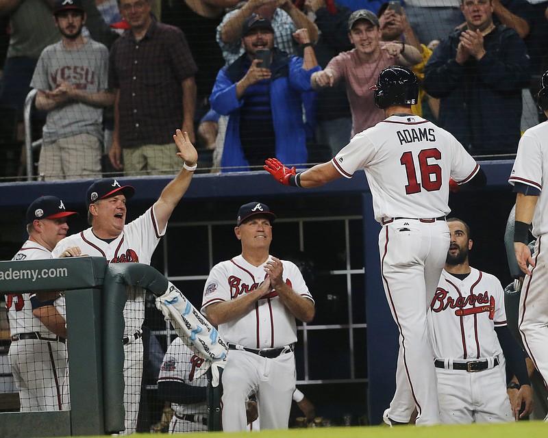 Atlanta Braves' Lane Adams (16) is greeted at the dugout by hitting coach Kevin Seitzer (28) , left, and manager Brian Snitker after hitting a three-run home run during the sixth inning of the team's baseball game against the San Francisco Giants on Thursday, June 22, 2017, in Atlanta. (AP Photo/John Bazemore)