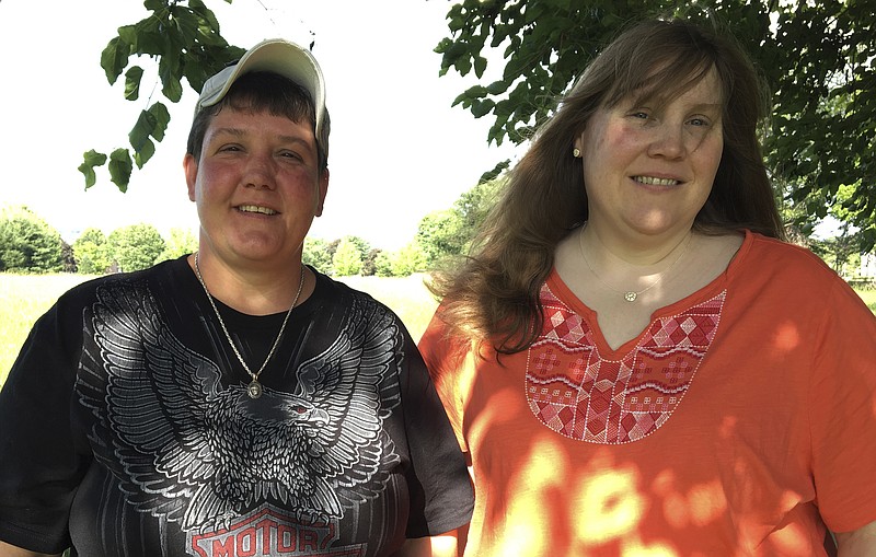 
              In this June 21, 2017 photo, Samantha "Sam" LaRochelle, left, stands with her wife, Audrey LaRochelle, at their home in Lopatcong Township, N.J., wearing the irreplaceable necklace that had been removed from her neck during an emergency visit to St. Luke's Hospital, in Phillipsburg on June 17, 2017. Staff at Covanta Energy Corp. in Oxford Township dug through a 15-ton pile of hospital waste to find it. (Kurt Bresswein/The Express-Times via AP)
            