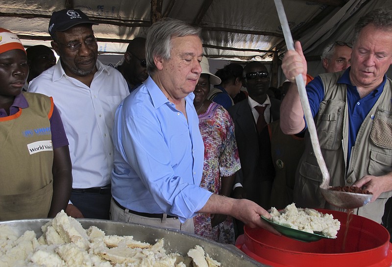
              United Nations Secretary-General Antonio Guterres, center, serves maize meal to refugees in the food distribution tent of the Imvepi reception center for South Sudanese refugees in northern Uganda, Thursday, June 22, 2017. Guterres visited ahead of a U.N.-backed summit in Uganda that is aimed at raising global awareness of the world's fastest-growing refugee crisis and urged South Sudan's leaders to end a civil war that has killed tens of thousands and displaced millions of people. (AP Photo/Rodney Muhumuza)
            