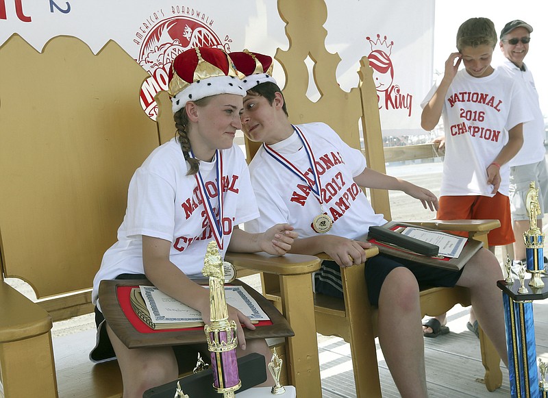 
              Eli Murphy, right, leans in to give Sierra Ricci the traditional king and queen kiss at the National Marbles Championship in Wildwood, N.J., Thursday, June 22, 2017.  Ricci and Eli Murphy, both of Allegheny County Pa., won the girls and boys championship of the 94th annual National Marbles Tournament. (Dale Gerhard/The Press of Atlantic City via AP)
            