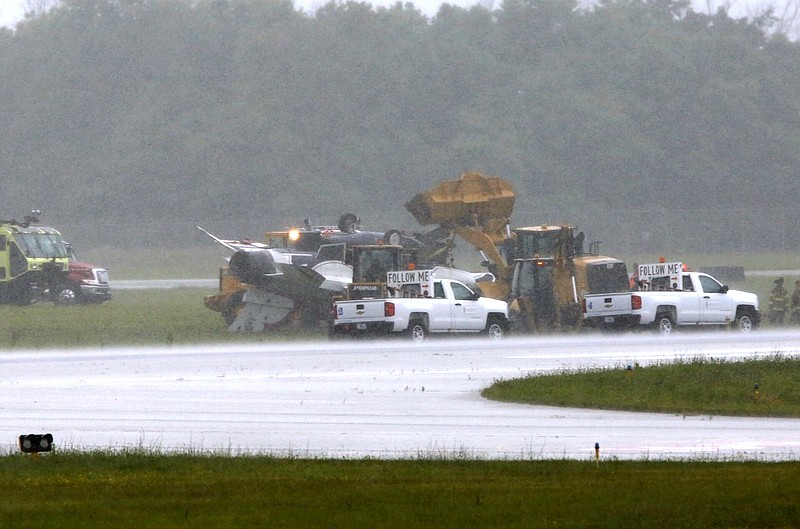 
              A military jet is attended to after flipping over at the Dayton International Airport on Friday, June 23, 2017, in Dayton, Ohio. (Ty Greenlees /Dayton Daily News via AP)
            