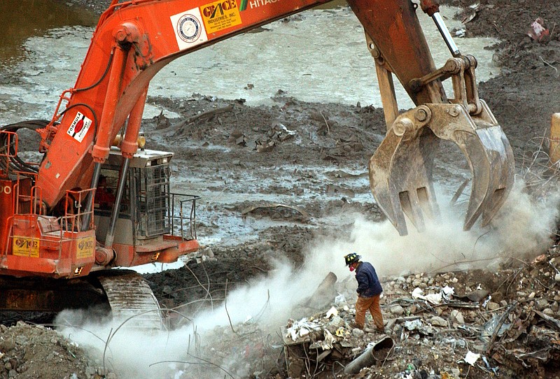 
              In this Jan. 8, 2001 file photo, a rescue worker wearing a dust mask, peers through a cloud of dust created by an excavator at the World Trade Center site in New York. The New York governor's pardon of Carlos Cardona for a 1990 drug conviction is the latest example of politicians trying to rescue individuals from their immigration problems. Cardona worked on the World Trade Center recovery operation after the 2001 terrorist attacks. (AP Photo/Mark Lennihan, File)
            