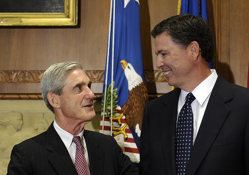 
              FILE - In this Sept. 4, 2013, file photo, then-incoming FBI Director James Comey talks with outgoing FBI Director Robert Mueller before Comey was officially sworn in at the Justice Department in Washington. Mueller, the somber-faced and demanding FBI director who led the bureau through the Sept. 11 attacks, and Comey, his more approachable and outwardly affable successor, may be poles apart stylistically but both command a wealth of respect in the law enforcement and legal community. (AP Photo/Susan Walsh, File)
            