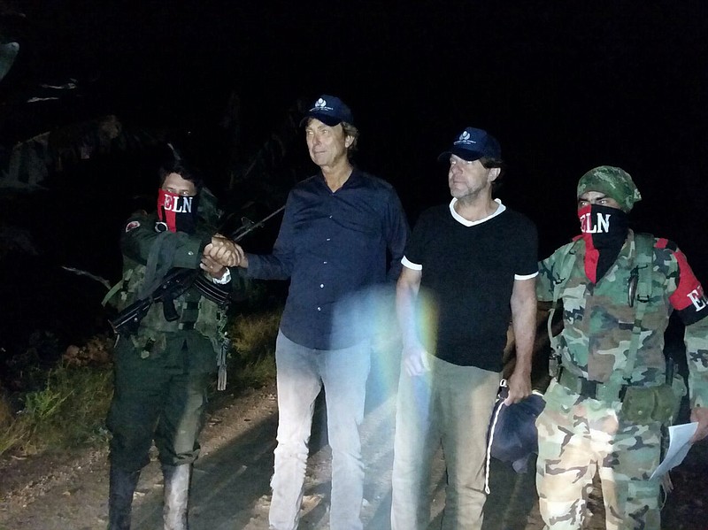 
              In this photo released by Colombia's Ombudsman Press Office, rebels of Colombia's National Liberation Army, ELN, release Dutch journalists Derk Bolt, second from left, and Eugenio Follender, second from right, north of Santander, Colombia, Saturday, June 24, 2017. The two Dutch journalists, who were held captive for almost a week by the leftist rebels in Colombia, were released unharmed, Dutch Foreign Affairs Minister Bert Koenders said early Saturday. (Colombia's Ombudsman Press Office via AP)
            
