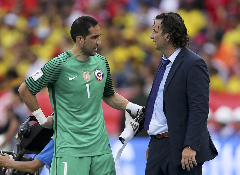 
              FILE - In this Thursday, Nov. 10, 2016 file photo, Chile goalkeeper Claudio Bravo, left, talks to coach Juan Pizzi during a 2018 World Cup qualifying soccer match against Colombia in Barranquilla, Colombia. Chile coach Juan Antonio Pizzi says Claudio Bravo is fit again and could start in goal against Australia at the Confederations Cup on Sunday. Bravo hasn't played since April 27, when he injured his calf for Manchester City in a derby game with Manchester United. (AP Photo/Fernando Vergara, File)
            