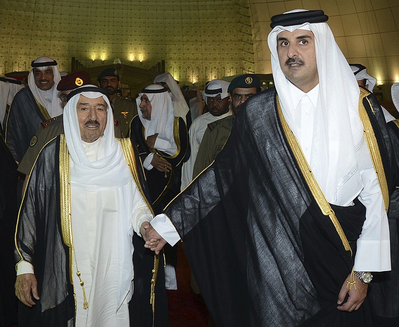 
              FILE- In this Wednesday, June 7, 2017 file photo released by Kuwait News Agency, KUNA, Kuwait's Emir Sheikh Sabah Al Ahmad Al Sabah, left, holds the hand of Qatar's Emir Sheikh Tamim bin Hamad Al Thani in Doha, Qatar. Acting as a mediator, Kuwait has presented Qatar a long-awaited list of demands from Saudi Arabia, Bahrain, the United Arab Emirates and Egypt, four Arab nations that cut ties with Qatar in early June 2017. (KUNA via AP, File)
            