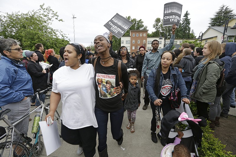 
              People begin a march through a courtyard following a vigil outside where a pregnant mother was shot and killed Sunday by police, Tuesday, June 20, 2017 in Seattle. Police officers shot and killed 30-year-old Charleena Lyles after Lyles, authorities said, confronted the officers with knives. (AP Photo/Elaine Thompson)
            