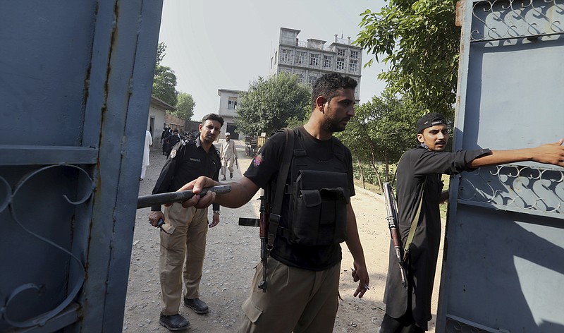 
              Pakistani police officer stand guard at the main gate of alleged militant hideout following a shootout on the outskirts of Peshawar, Pakistan, Saturday, June 24, 2017. Security forces raided a militant hideout in the northwestern city of Peshawar before dawn Saturday, triggering a shootout in which three Pakistani Tailban were killed, senior police official Sajjad Khan said. (AP Photo/Muhammad Sajjad)
            