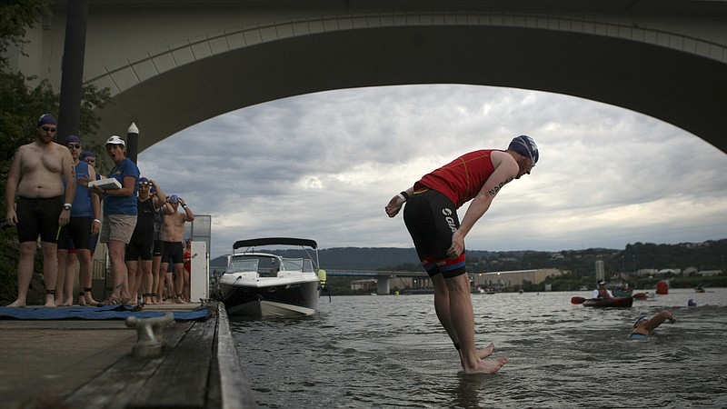 Harrison Powell breaks the surface of the water as he jumps into the Tennessee River for the sprint swim during the Chattanooga Waterfront Triathlon on Sunday, June 25, in Chattanooga, Tenn. Powell competed in the sprint race, which included a 400m swim, a 20k bike ride and a 5k run.