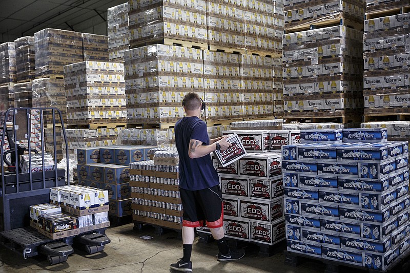 A worker, one of many who could use a pat on the back for doing their daily jobs without complaint, fulfills an order at Carter Distributing Co.