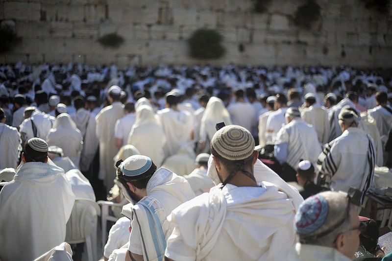 
              FILE -- In this May 24, 2017 file photo, Jewish men pray at the Western Wall, the holiest place where Jews can pray, in Jerusalem's Old City, during Jerusalem Day celebrations. An Israeli official said Sunday, June 25, 2017 that the government has frozen a long-overdue plan to open a mixed-gender prayer area at Jerusalem's Western Wall. (AP Photo/Ariel Schalit, File)
            