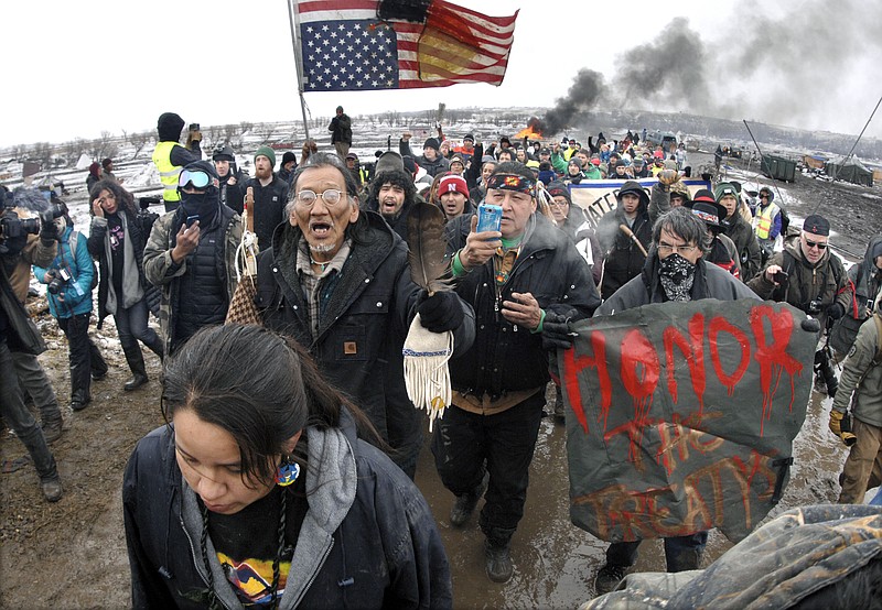 
              FILE - In this Feb. 22, 2017, file photo, a large crowd of the remaining Dakota Access Pipeline protesters march out of the Oceti Sakowin camp before the deadline set for evacuation of the camp mandated by the U.S. Army Corps of Engineers near Cannon Ball, N.D. A federal judge's order for more environmental review of the already-operating pipeline has several potential outcomes, all of which could spark even more wrangling in court.  (Mike McCleary/The Bismarck Tribune via AP, File)
            