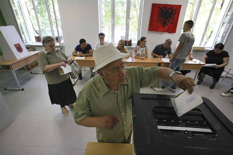 
              An Albanian man casts his ballot at a polling station in Tirana, Sunday, June 25, 2017. Albanians were voting Sunday in a general election that follows a landmark agreement between the country's two biggest political parties to look past their bitter differences and back efforts for Albania to eventually join the European Union. (AP Photo/Hektor Pustina)
            