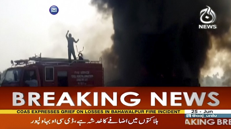 
              In this image taken from video, black smoke rises from oil tanker on road in Bahawalpur, Pakistan, Sunday,  June 25, 2017.  An overturned oil tanker burst into flames in Pakistan on Sunday, killing people who had rushed to the scene of the highway accident to gather leaking fuel, an official said. (AAJ News via AP Video)
            