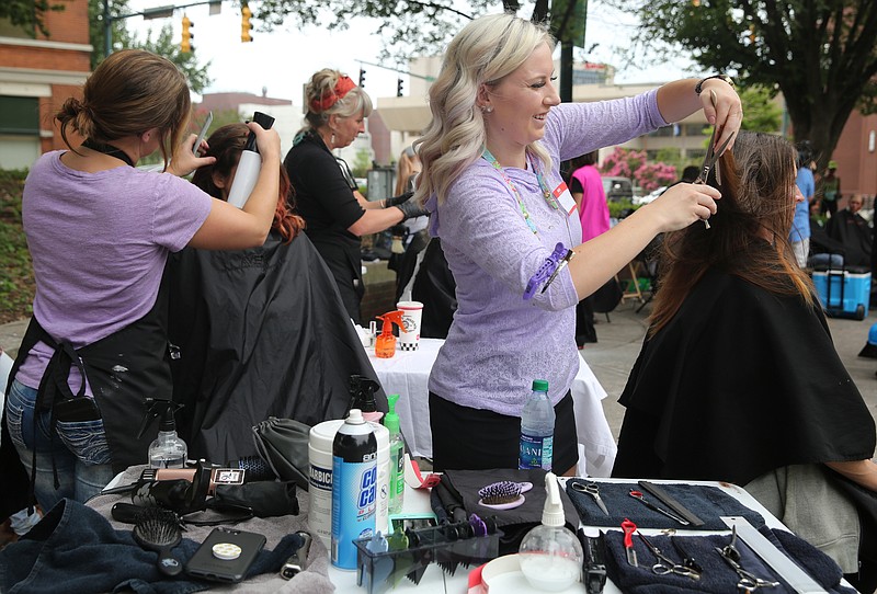 At the right, Taylor Keef of Hair Benders Internationale cuts Audrey Albritton's hair during a Cuts for Change event Monday, June 26, 2017, at Miller Park in Chattanooga, Tenn. Cuts for Change is an organized effort to inspire confidence and redemption through providing haircuts and hygiene packs to those in the community that can't afford them. 