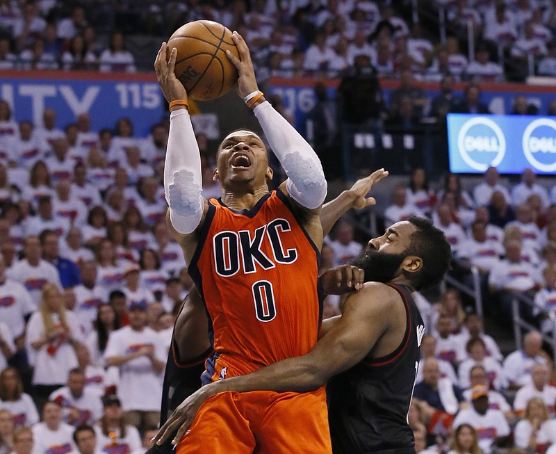 
              FILE - In this April 23, 2017 file photo, Oklahoma City Thunder guard Russell Westbrook (0) shoots between Houston Rockets guard Patrick Beverley, rear, and guard James Harden, right, in the fourth quarter of Game 4 of a first-round NBA basketball playoff series in Oklahoma City. Westbrook will join Houston’s James Harden and San Antonio’s Kawhi Leonard as finalists for the league’s MVP award. The winner will be announced Monday, June 26, at the inaugural NBA Awards show. (AP Photo/Sue Ogrocki, File)
            