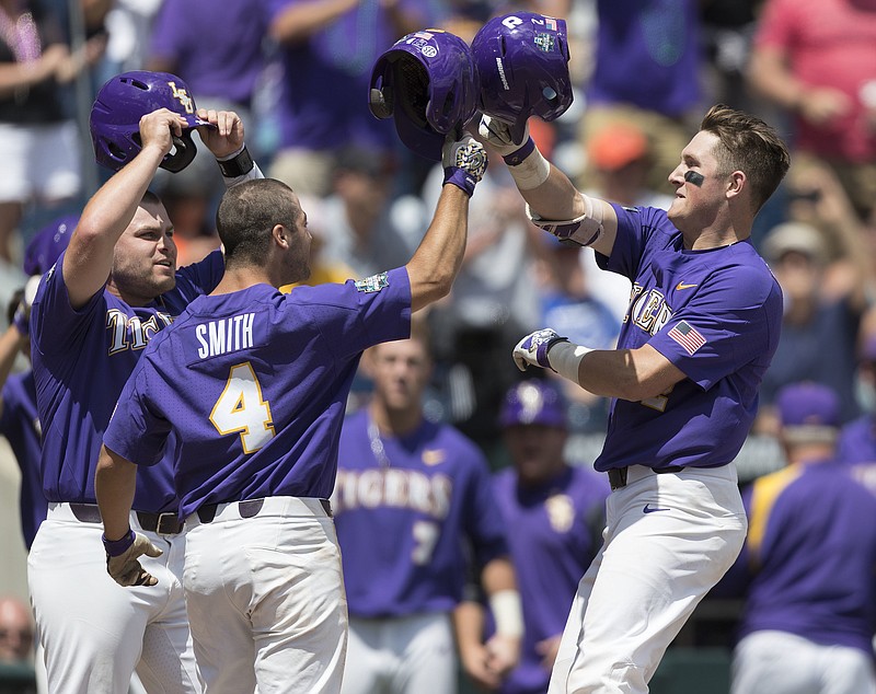 
              LSU's Michael Papierski, right, is greeted by Josh Smith (4) and Beau Jordan after hitting a three-run home run against Oregon State during a College World Series baseball game Saturday, June 24, 2017, in Omaha, Neb. (Ryan Soderlin/Omaha World-Herald via AP)
            