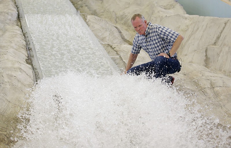 
              In this Friday, June 16, 2017, photo, hydraulic engineering professor Michael Johnson looks at the water flow on a replica of the Oroville Dam spillway at Utah State University's Water Research Laboratory, in Logan, Utah. California water officials are relying on key hydrology tests being performed on the replica of the spillway to pinpoint what repairs will work best at the tallest dam in the U.S for a spillway that was torn apart in February. (AP Photo/Rick Bowmer)
            
