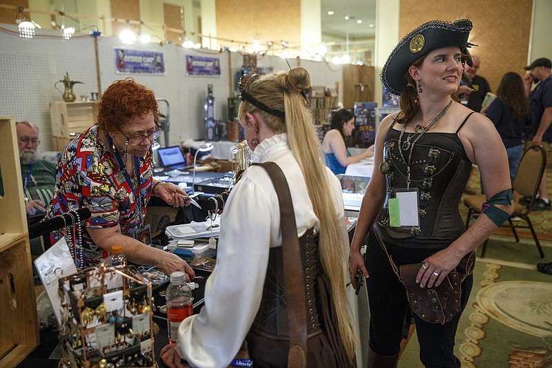 Marcia Illingworth, left, with Magpie Curios, helps Jasmine DeGroot, center, and Melanie Boyd select jewelry at the 29th annual LibertyCon at the Chattanooga Choo Choo on Saturday, July 9, 2016, in Chattanooga. The annual celebration of science fiction and fantasy literature, art, and culture included panel discussions with authors and a variety of sci-fi and fantasy vendors.