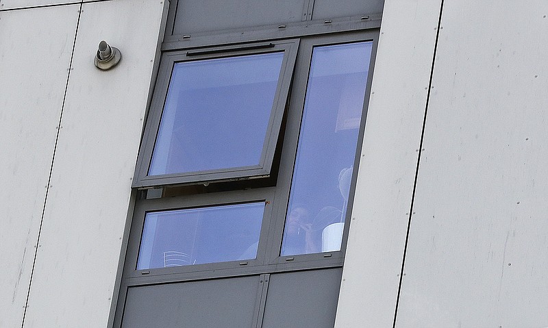 
              A woman speaks on the phone behind her flat window of Bray Tower, part of the Chalcots Estate in the borough of Camden, in London, Monday, June 26, 2017. The apartments were evacuated after fire inspectors concluded that the buildings were unsafe because of problematic fire doors, gas pipe insulation, and external cladding similar to that blamed for the rapid spread of a fire that engulfed Grenfell Tower on June 14. (AP Photo/Frank Augstein)
            