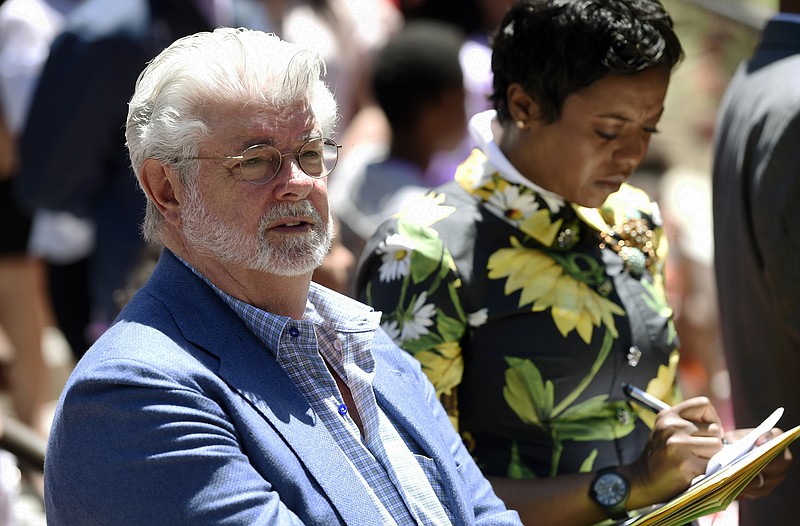 
              Filmmaker George Lucas, left, and his wife Mellody Hobson listen to remarks at a news conference outside Los Angeles City Hall on Tuesday, June 27, 2017. The Los Angeles City Council approved preliminary steps that will allow construction of the $1.5 billion Lucas Museum of Narrative Art in Exposition Park in Los Angeles. (AP Photo/Chris Pizzello)
            