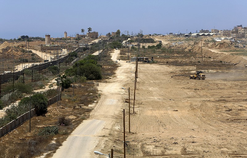 
              A bulldozer works on creating a buffer zone along the Egyptian border with the Gaza strip, near Egyptian army watch towers, left, and near smuggling tunnels, right, in Rafah, Wednesday, June 28, 2017. The Hamas-run Interior Ministry said Wednesday the creation of a 12-kilometer-long (7.5-mile) corridor 100 meters (330 feet) wide was agreed upon in recent face-to-face negotiations with Egyptian officials and is part of the Islamic militant group's efforts to combat extremists and improve ties with Cairo. (AP Photo/Adel Hana)
            