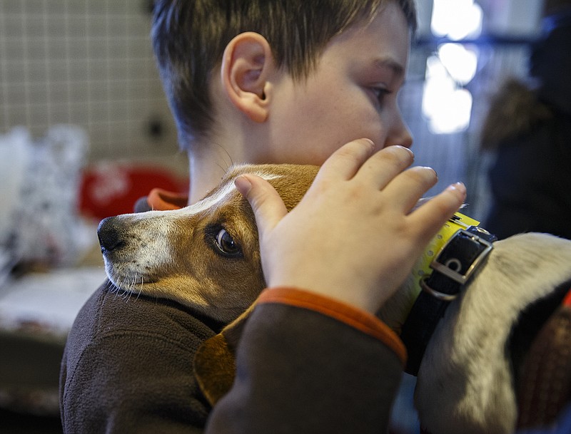Thomas Aultman hugs Snoopy the dog, who his family will foster for the holidays, at the Humane Educational Society on Friday, Dec. 23, 2016, in Chattanooga, Tenn. The Humane Society needs volunteers to help foster pets through the holiday season.