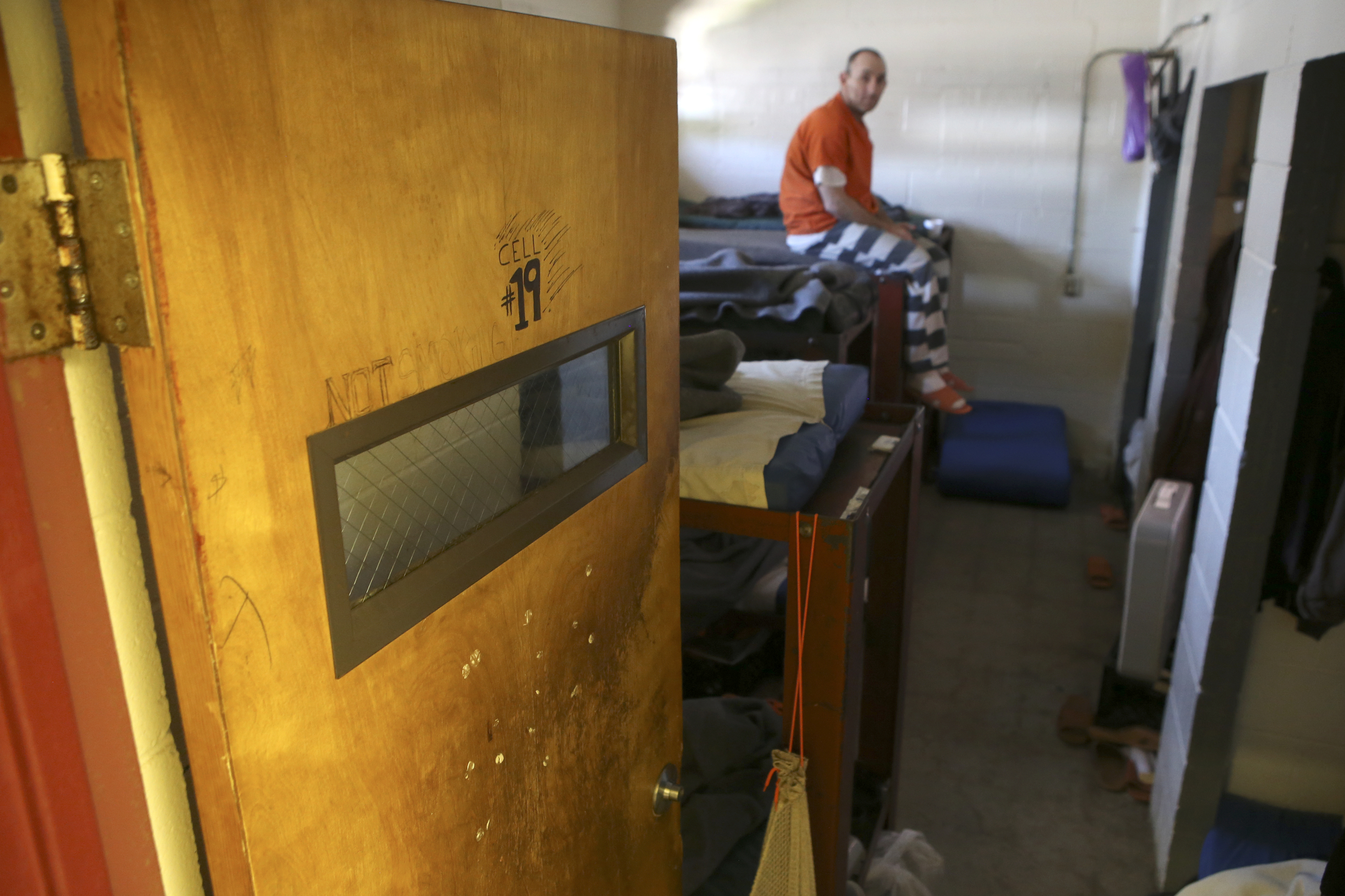 An inmate sits on his bunk, in an office that was converted into a cell, in trusties hall at the Rhea County Jail on Wednesday, June 28, in Dayton, Tenn.