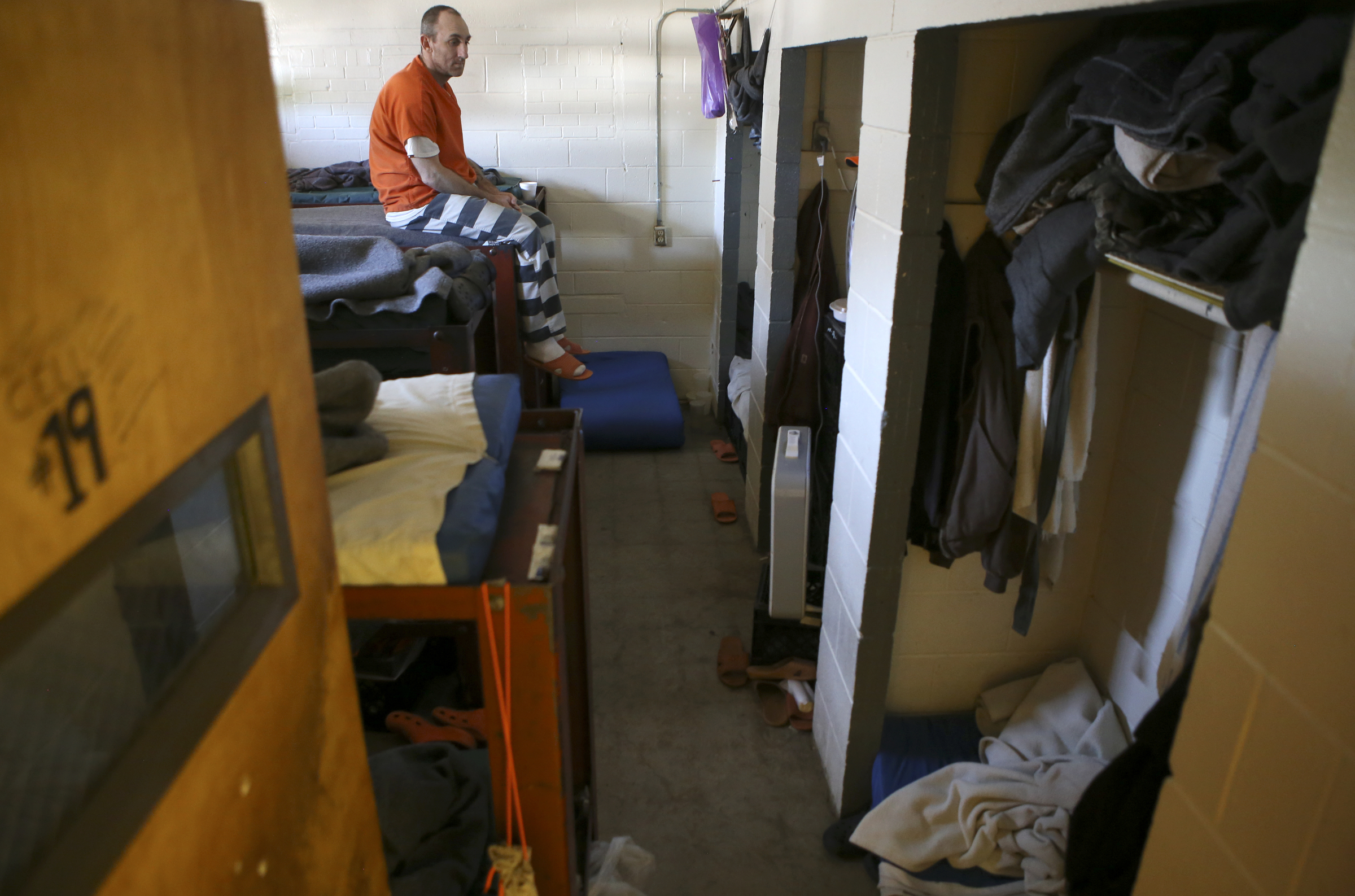 An inmate sits on his bunk, in an office that was converted into a cell, in trusties hall at the Rhea County Jail on Wednesday, June 28, in Dayton, Tenn.