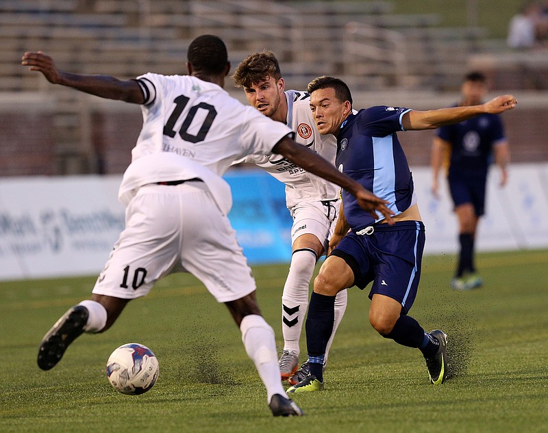 Chattanooga Football Club's John Carrier, in blue, competes with Memphis FC's Mario Hyman (10) and Lewis Jones for the ball during Wednesday's match at Finley Stadium. Memphis rallied from a 1-0 deficit to win 2-1 and drop CFC to 4-1-1 in league play this season.