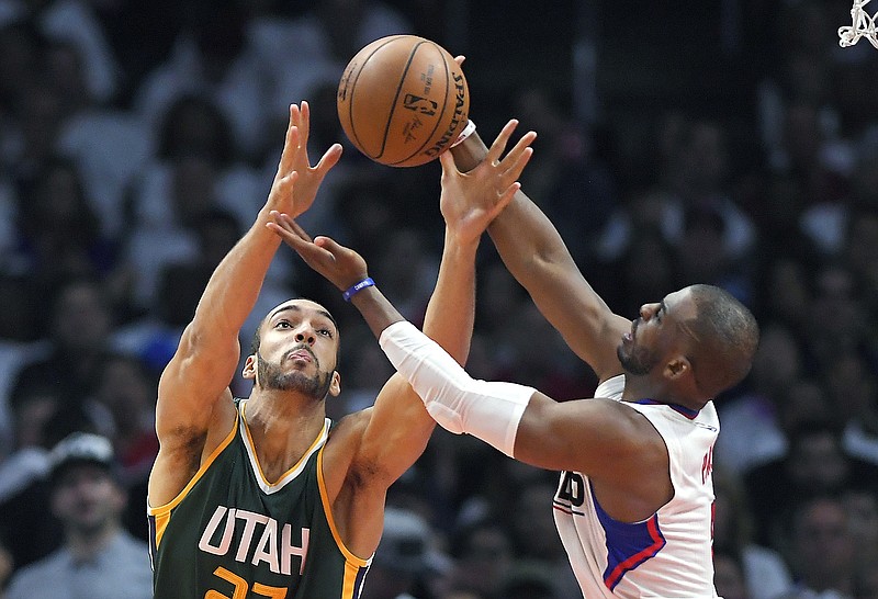 Chris Paul, right, competes with Utah Jazz center Rudy Gobert for a rebound during an L.A. Clippers playoff game in April. On Wednesday, Paul was traded to the Houston Rockets.