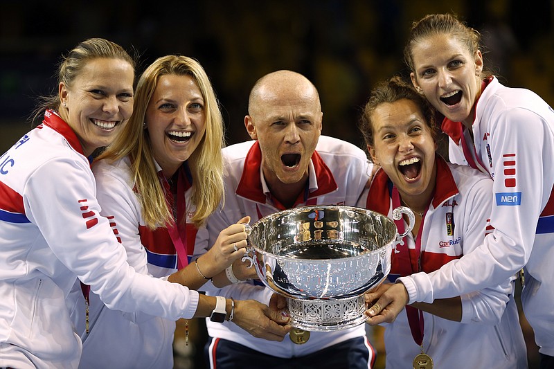 
              FILE - This is a Sunday, Nov. 13, 2016 file photo of the  Czech Republic team captain Petr Pala, center, and players hold the trophy after their victory against France, during the Fed Cup final in Strasbourg, eastern France.  The Davis Cup and Fed Cup are planning to combine forces into a World Cup of Tennis. A three-year deal starting in 2018 to combine the events was announced Wednesday June 28, 2017, by the International Tennis Federation. The changes still need to be approved at the federation’s annual general meeting in August in Vietnam. (AP Photo/Jean-Francois Badias/File)
            