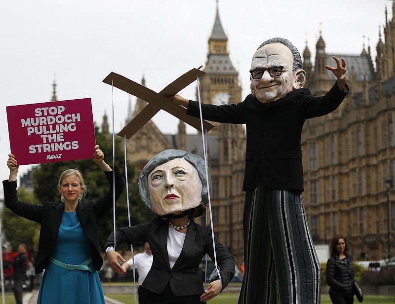 
              Campaigners from the community-based organization Avaaz, wearing a mask of Rupert Murdoch, right, and Prime Minister Theresa May, stage a protest opposite parliament in London, Thursday, June 29, 2017. Britain’s Culture Secretary Karen Bradley  is ruling on whether to permit the proposed 11.7 billion pound merge of Sky and Twenty-First Century Fox.  Bradley is set to offer her verdict Thursday. The merger would allow Rupert Murdoch to consolidate his power base in British media. (AP Photo/Frank Augstein)
            