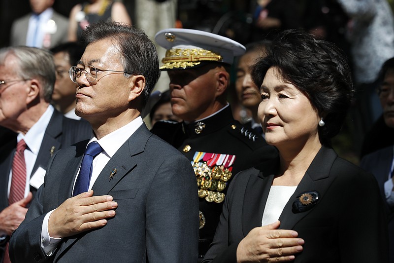 
              South Korean President Moon Jae-in, left, with his wife Kim Jung-sook, and Marine Corps Commandant Gen. Robert B. Neller, center, place their hands over their hard during the playing of national anthems for South Korea and the United States during a ceremony at the "Chosin Few Battle Monument," at the National Museum of the Marine Corps, Wednesday, June 28, 2017, in Triangle, Va. (AP Photo/Alex Brandon)
            