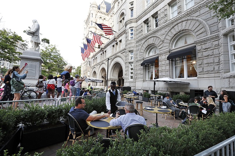 
              Protesters yell at patrons at the outdoor seating area at the Trump International Hotel, Wednesday, June 28, 2017, in Washington. President Donald Trump is attending a fundraiser at the hotel. (AP Photo/Alex Brandon)
            